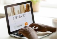 August Hiring Pops—Who Loses Now? Hands typing on laptop with job search website open