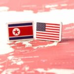 Flags of North Korea and the United States on a map of East Asia
