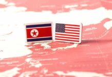 Flags of North Korea and the United States on a map of East Asia