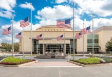 American flags at half-staff around a library entrance