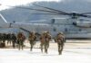 Trump Claims VICTORY – Troops Out Soldiers disembark and walk past a large military helicopter