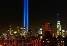New York City skyline at night with twin blue light beams