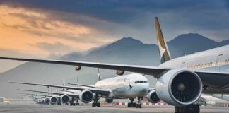Commercial airliners lined up on an airport taxiway at dusk