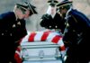 Honor guard carrying a flag-draped casket