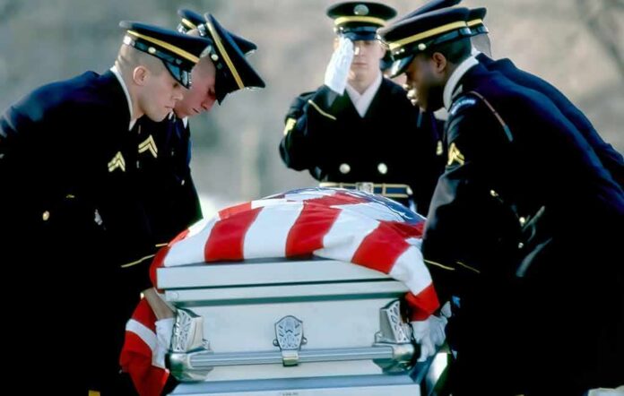 Honor guard carrying a flag-draped casket