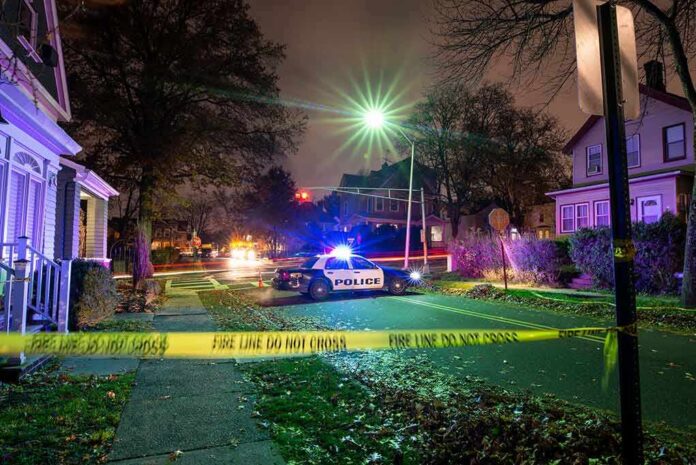 shutterstock_1793905801 Police car blocks residential street at night behind caution tape