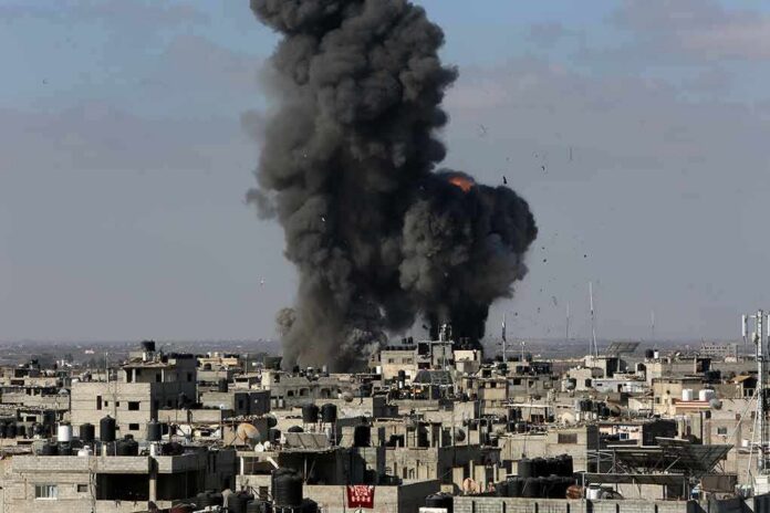 Thick black smoke rises from an explosion over a dense urban area