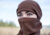 Tatiana Akimova wearing a brown headscarf covering lower face outdoors