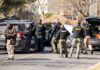 Police Call It Homicide — Mother Hospitalized Police and sheriff officers gather around vehicles on a suburban street