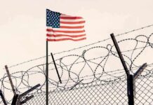 American flag above barbed wire fence
