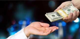 Hands exchanging a stack of US dollar bills