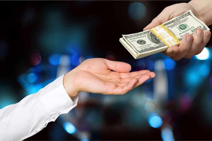 shutterstock_345297710 Hands exchanging a stack of US dollar bills