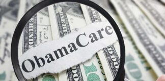 Magnifying glass over cash highlighting Obamacare text