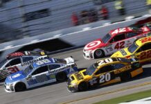 Stock cars racing side by side on a banked track