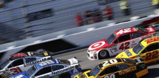 Stock cars racing side by side on a banked track