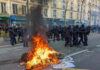 France Erupts: Students vs. Riot Police Fire burning on the street amid police presence.
