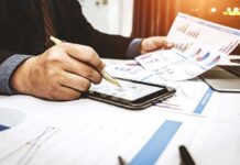 Tax Man Cornered Zuckerberg? Businessperson analyzing charts with tablet and papers