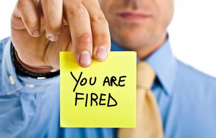 shutterstock_104307521 man in business attire holding a yellow sticky note toward the camera