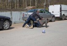 France ERUPTS: 550,000 Hit The Streets Men scuffle on a street beside parked cars