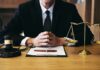 RICO Blitz Targets Manhattan Injury Mill Judge at desk with gavel and scales of justice