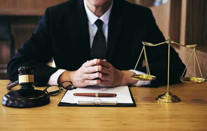 Judge at desk with gavel and scales of justice