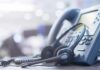 Headset resting on an office desk phone