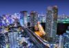 City skyline at night with illuminated skyscrapers and highways
