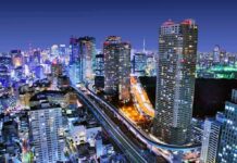 Murder Charge Ignites Okinawa Fury City skyline at night with illuminated skyscrapers and highways