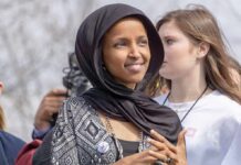 Immigration Probe Zeroes In On Rep. Ilhan Omar Ilhan Omar wearing a black headscarf at an outdoor event