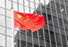 Watch List Again: Hong Kong Fumes Chinese flag waving against glass office building