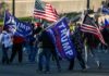 Nicki Minaj Twist at Trump Rally Crowd of people carrying political and American flags at a street gathering