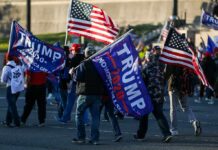 Nicki Minaj Twist at Trump Rally Crowd of people carrying political and American flags at a street gathering