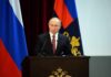 Putin Meeting: Surprise American Walks Free speaker at podium with flags in background