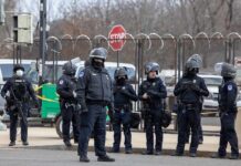 UK Terror Probe Points Straight To Iran Group of police officers in riot gear standing on a street; Brian Folkerts present