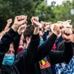 Orléans Locked Down – Protesters Surge Crowd of protesters with raised fists wearing masks