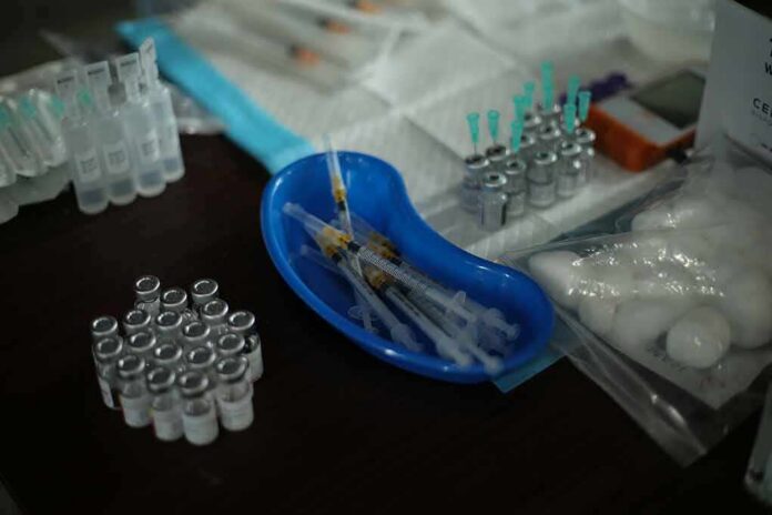 shutterstock_2064455483 Medical syringes and vials arranged on a table