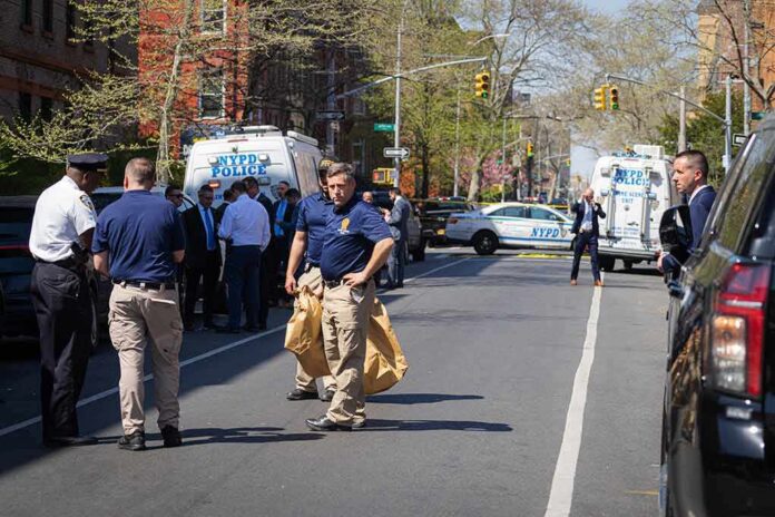 shutterstock_2289044007 Police officers and investigators at a blocked city street scene