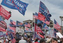 Trump Rally Sparks $4B Audi Bet Crowd at political rally with many American and campaign flags