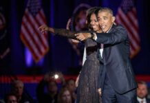 Obama’s Pick Triggers Communist Muslim Uproar Michelle Obama and Rob Nabors pointing on stage at an event