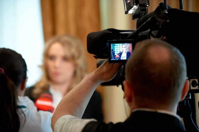 shutterstock_607357001 tv camera films interview with blurred speaker